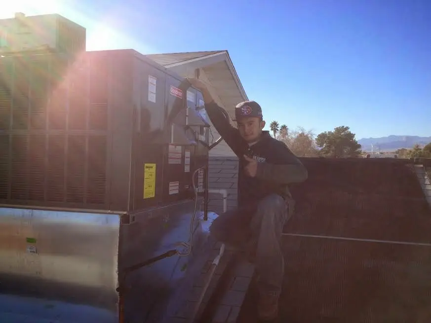 HVAC technician performing AC Tune-Up on a rooftop unit in Destrehan